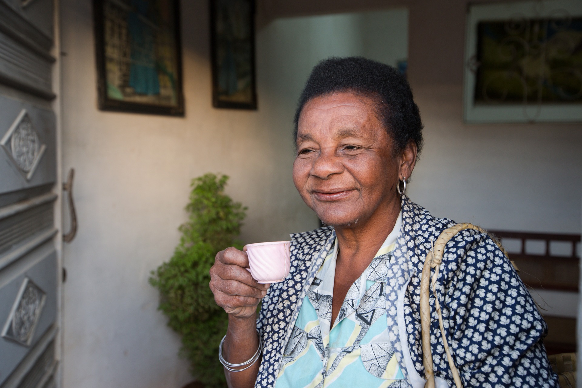An elderly woman drinking tea and smiling An elderly woman drinking tea and smiling